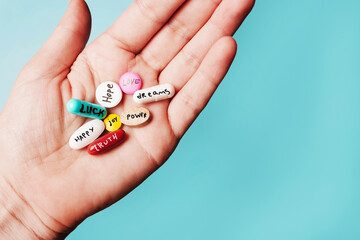 concept of creative pills, a placebo in the hand, with joy, love, happiness, truth, power, dream