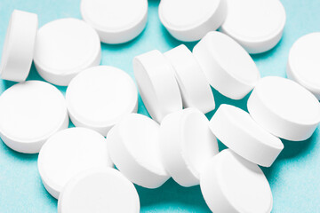 Round, white pills on a blue background.