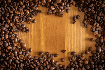 Coffee beans scattered on a wooden table.
