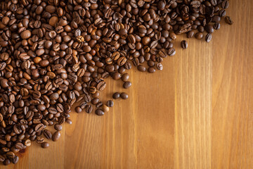 Coffee beans scattered on a wooden table.