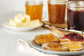 Slice of fresh bread with butter and jam on table