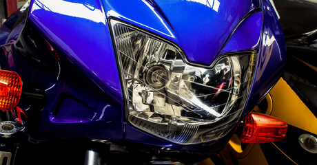 headlight of a sports motorcycle. Closeup photo in front. Shiny iridescent purple bike. Banner for web site