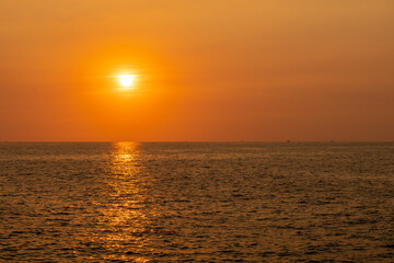 Fishing boat sails along the sea in the evening before sunset. Silhouette view