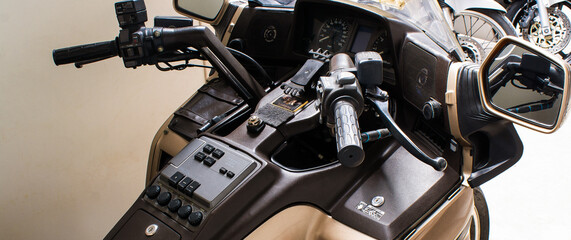 Dashboard of motorcycle steering wheel close-up. Moto handles, with windshield, mirrors, speaker,...