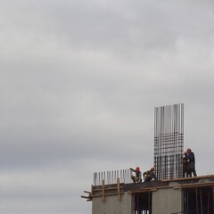 Manual erection of the steel formwork of a solid cast high-rise building made of cement.