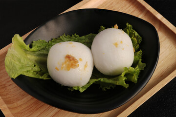 Mochi dessert on wooden tray and black background. Close-up shoot.