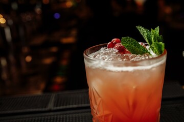 Cranberry summer lemonade decorated with mint on a bar counter