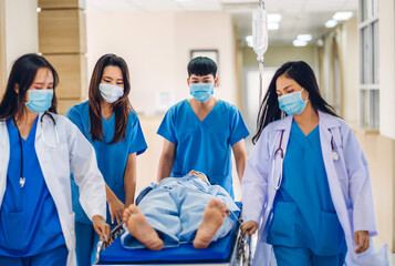 Group of professional medical doctor team and assistant with stethoscope in uniform taking seriously injured patient to operation emergency theatre room in hospital.health medical care concept