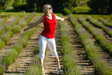 Beautiful provence woman relaxing in lavender field watching on sunset holding basket with lavanda flowers. blond lady in blossom field