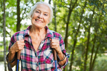 Zufrieden lächelnde Seniorin beim Nordic Walking