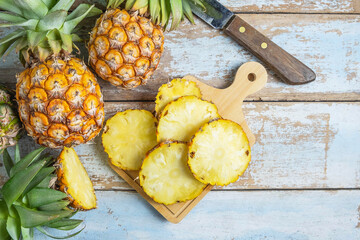 Fresh pineapple fruit sliced ​​on a wooden cutting board