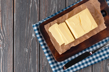 Wooden board with butter on blue checkered napkin