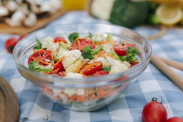 Fresh vegan salad outdoors on blue checkered napkin. Vegan food concept outdoor