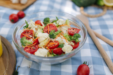 Fresh vegan salad outdoors on blue checkered napkin. Vegan food concept outdoor