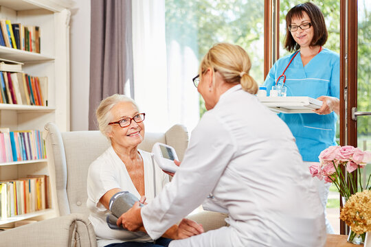 Krankenschwester misst Blutdruck bei einer Seniorin
