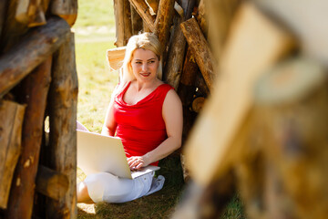 Euphoric woman searching job with a laptop in an urban park in summer