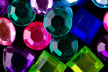 Fake gems jewels colorful on an isolated black background