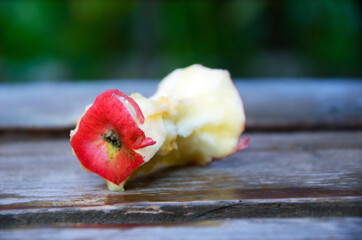 stub of a red apple on a wooden background.