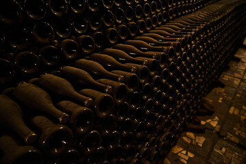 Image of wine bottles in an underground tunnel for aging wine.