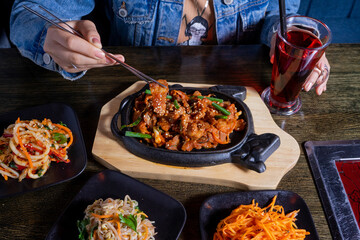 Asian lunch with meat, salads and lemonade on table