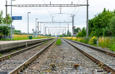 Fototapeta premium view of the train tracks leading off into the horizon at Altnau train station