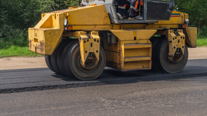 Close-up asphalt roller machinery. Road repair works on the suburb highway