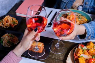 Cheers with wine glasses and asian food