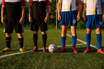 Football players from different teams stand on the football field before the match