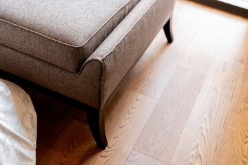 Fototapeta na wymiar closeup of detail leather sofa color tone with wooden floor background