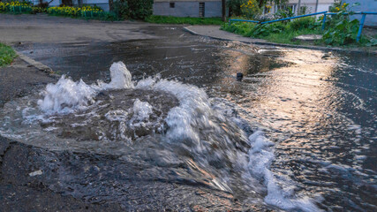 Overflowing Manhole cover with flood water pouring out.
