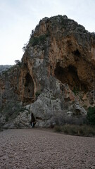 a woman in a cave in the Torrent de Pareis, Serra de Tramuntana, Mallorca, Spain, in the month of January