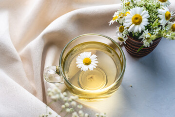 Transparent cup of hot chamomile tea. Concept of a healthy soothing herbal drink after a hard day...