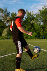 Young male soccer player juggles a ball on a soccer field © bo.kvk