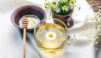 Transparent сup of hot chamomile tea and honey. Concept of a healthy soothing herbal drink after a hard day or in the morning