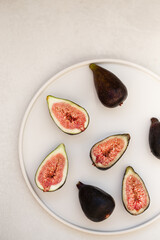 Minimalistic image of figs in a round white plate
