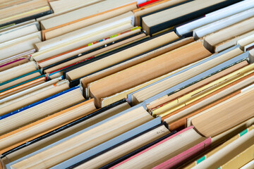 Vintage book background. Old and used hardback books stacked next to each other. Concept of education and studying. Nobody