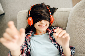 Woman with her hair on eyes enjoys music