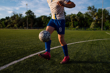 Young male soccer player juggles a ball on a soccer field © bo.kvk