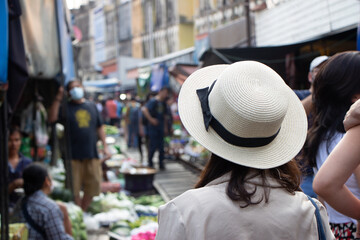 asia female tourists wearing hat holding camera and smartphone take photo vlog live. Beautiful woman take taxi boat visiting Damnoen Saduak floating market,Ratchaburi.