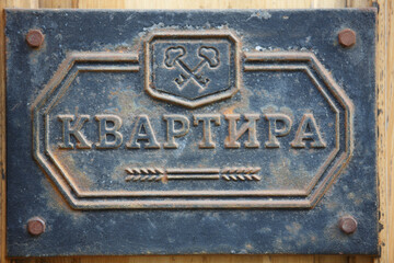 close up filled frame shot of a beautiful old weathered vintage retro blue metal door sign plate saying in Cyrillic Russian APARTMENT