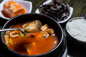 Hot asian soup with sea food. Mussels in spoon