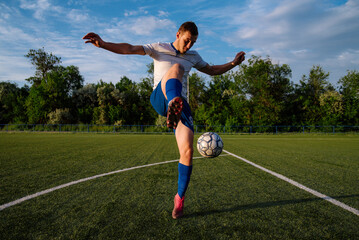 Young male soccer player juggles a ball on a soccer field © bo.kvk