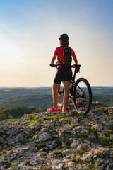 young woman admiring the awesome view over Frankonian Switzerland, during a mountain bike trip...