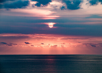 Beautiful colorful sunset on the background of the ocean and blue clouds on the island of Bali, Indonesia