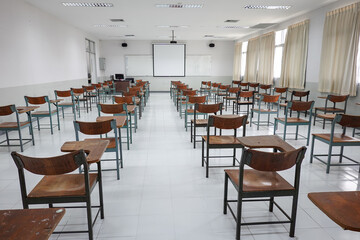 Empty classroom with vintage tone wooden chairs. Classroom arrangement in social distancing concept to prevent COVID-19 pandemic. Back to school concept.	