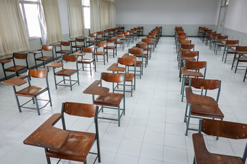 Empty classroom with vintage tone wooden chairs. Classroom arrangement in social distancing concept to prevent COVID-19 pandemic. Back to school concept.	