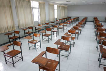 Empty classroom with vintage tone wooden chairs. Classroom arrangement in social distancing concept to prevent COVID-19 pandemic. Back to school concept.	