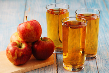 Glasses with apple juice and ripe apples