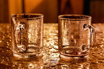 two empty tee cups on a rain coverd table