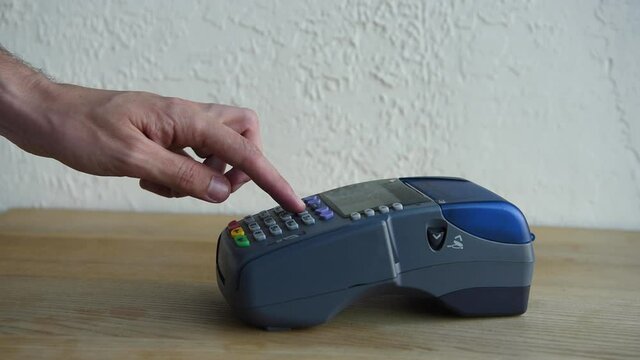 cropped view of man pushing buttons on payment terminal while using credit card